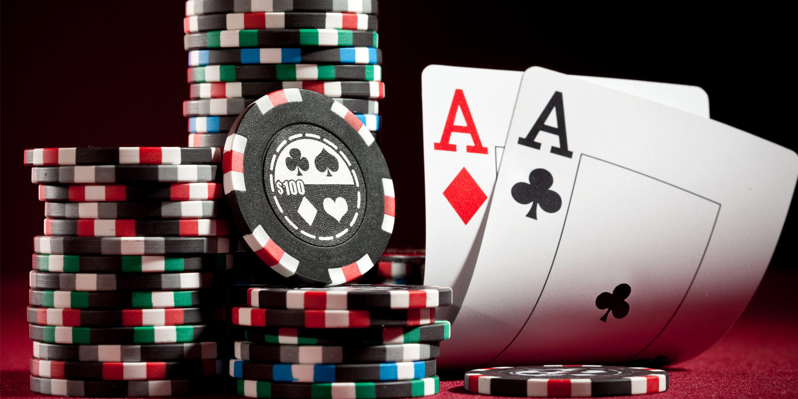 Pair of aces on a red felt table with columns of poker chips