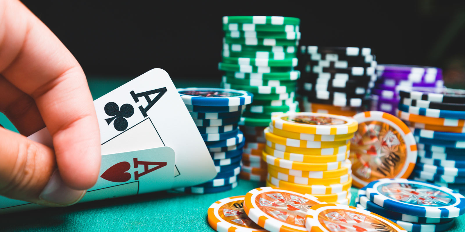 Pair of aces on a green felt table with columns of poker chips
