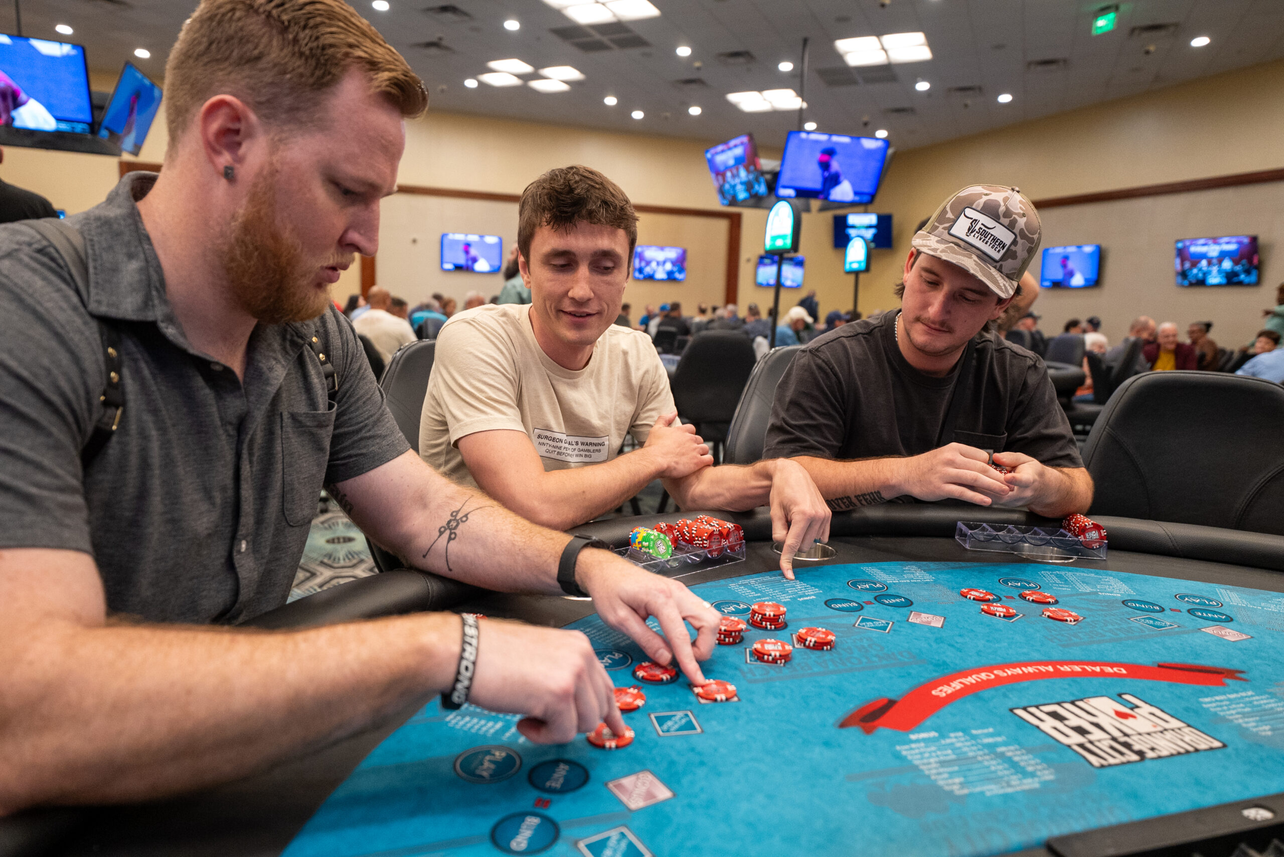 Three people placing chips on the poker table